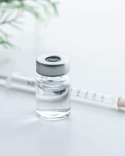 Image of Botox vial without label and syringe with needle.