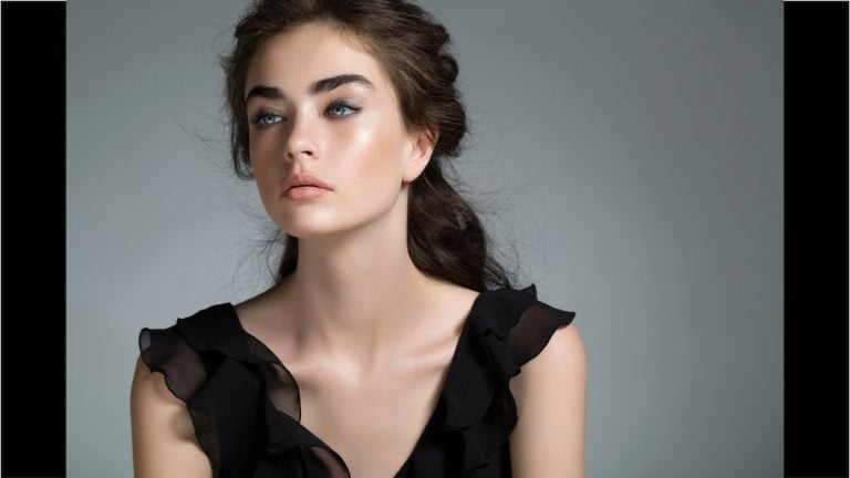 Woman in black dress with wrinkles smoothed after Daxxify injections