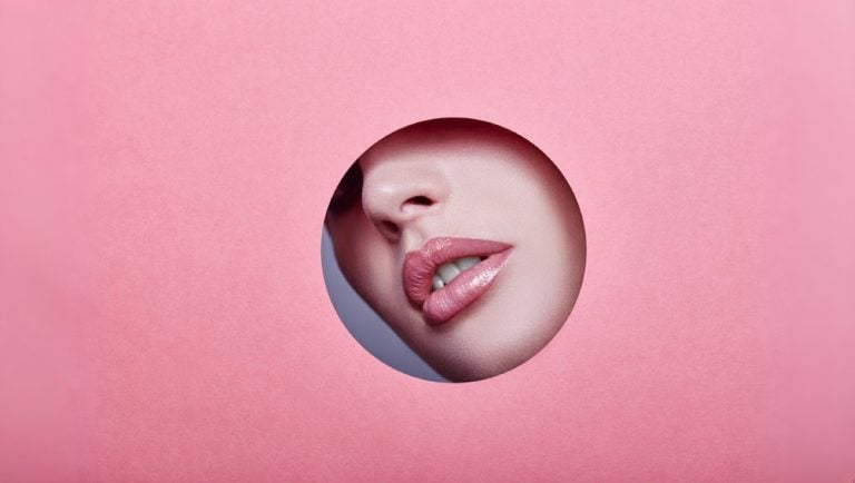 Woman with beautiful lips after lip filler with red lipstick.